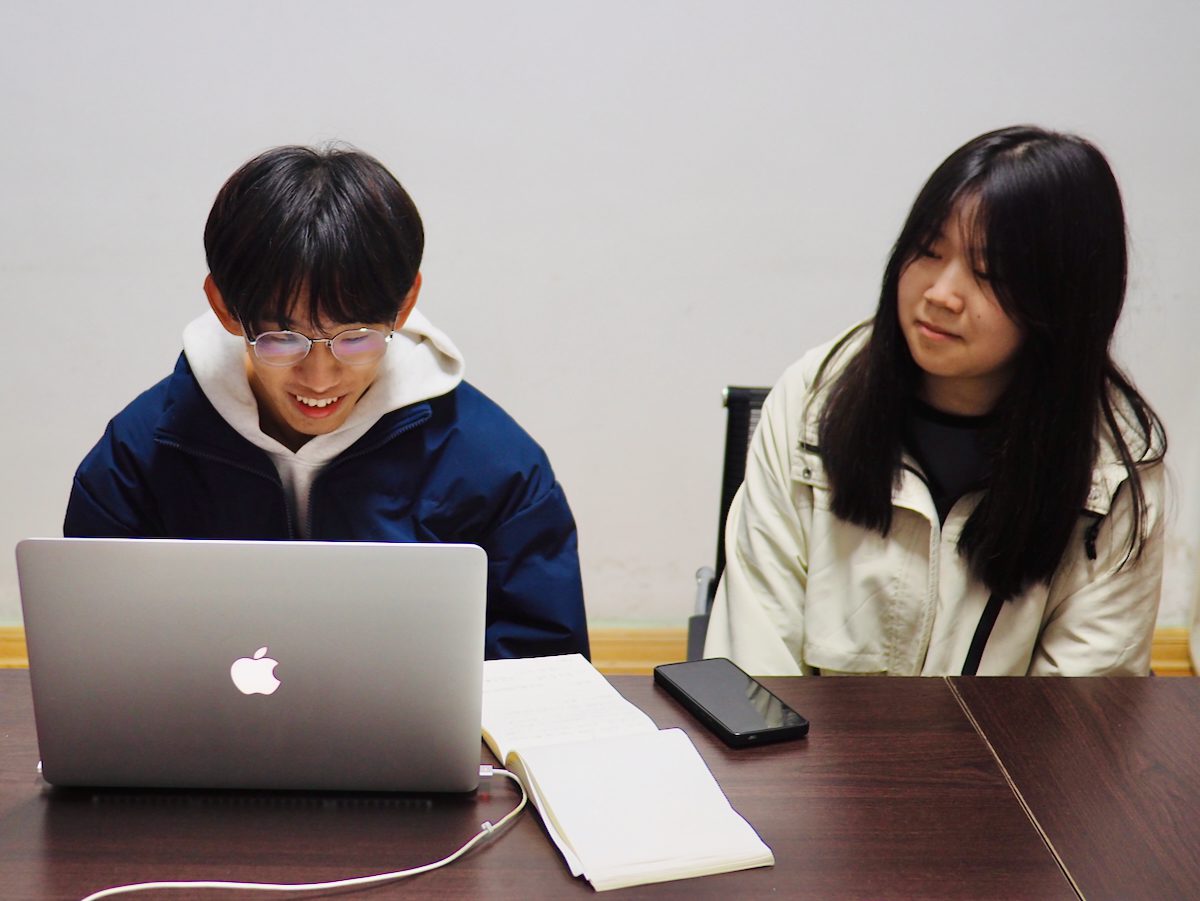 Ein Chinese und eine Chinesin im Gespräch mit einem Sprachtandempartner